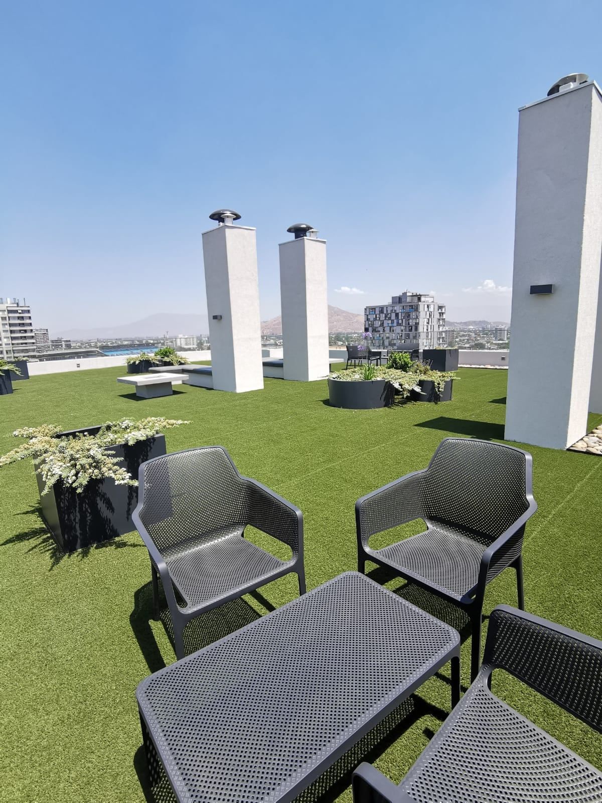 Sillones en la azotea de Activa Plaza Chacabuco, con vista a la ciudad