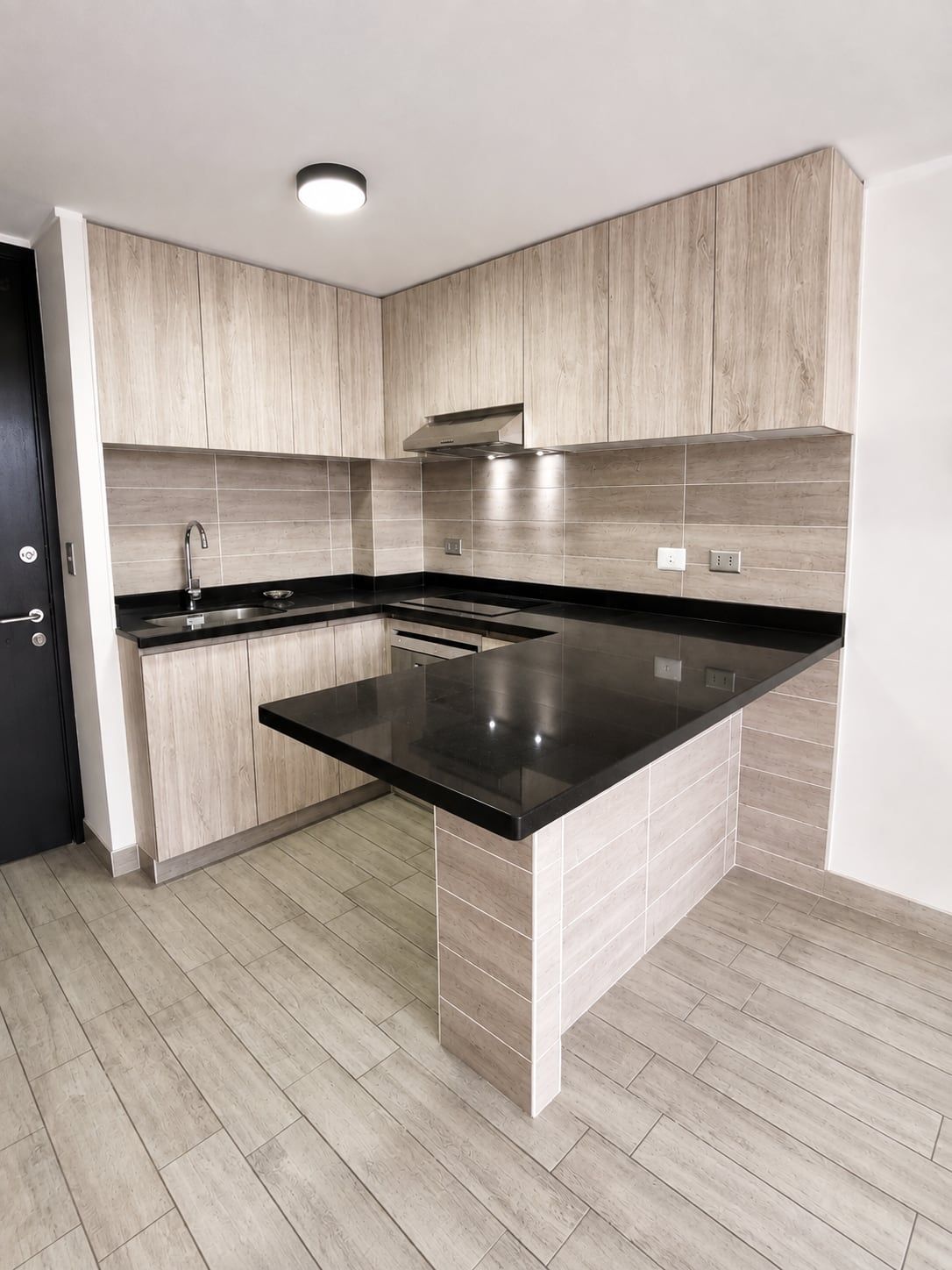 Cocina con cubierta negra de un departamento en Edificio Vergara