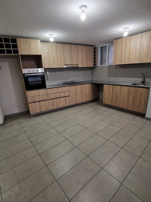 Cocina con muebles de madera de un departamento en Activa Entre Cerros