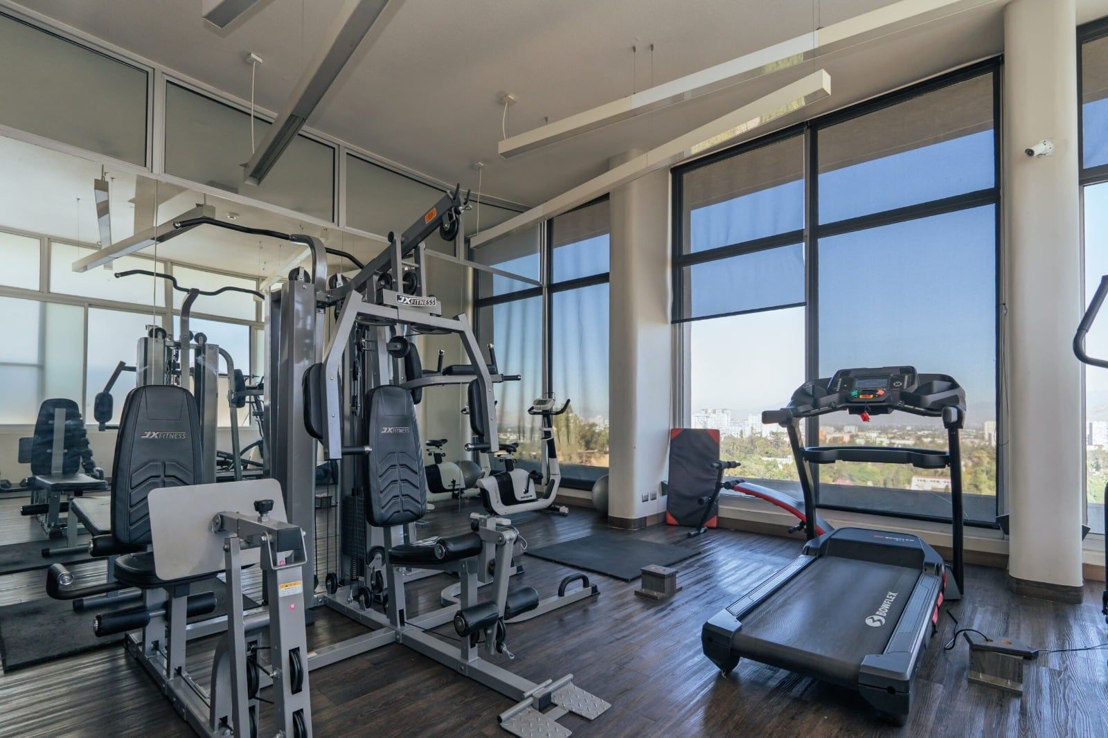 Gimnasio con máquinas y ventanales en Activa Entre Cerros