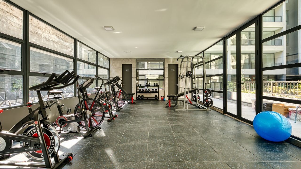 Gimnasio con bicicletas y ventanales en Edificio Vergara