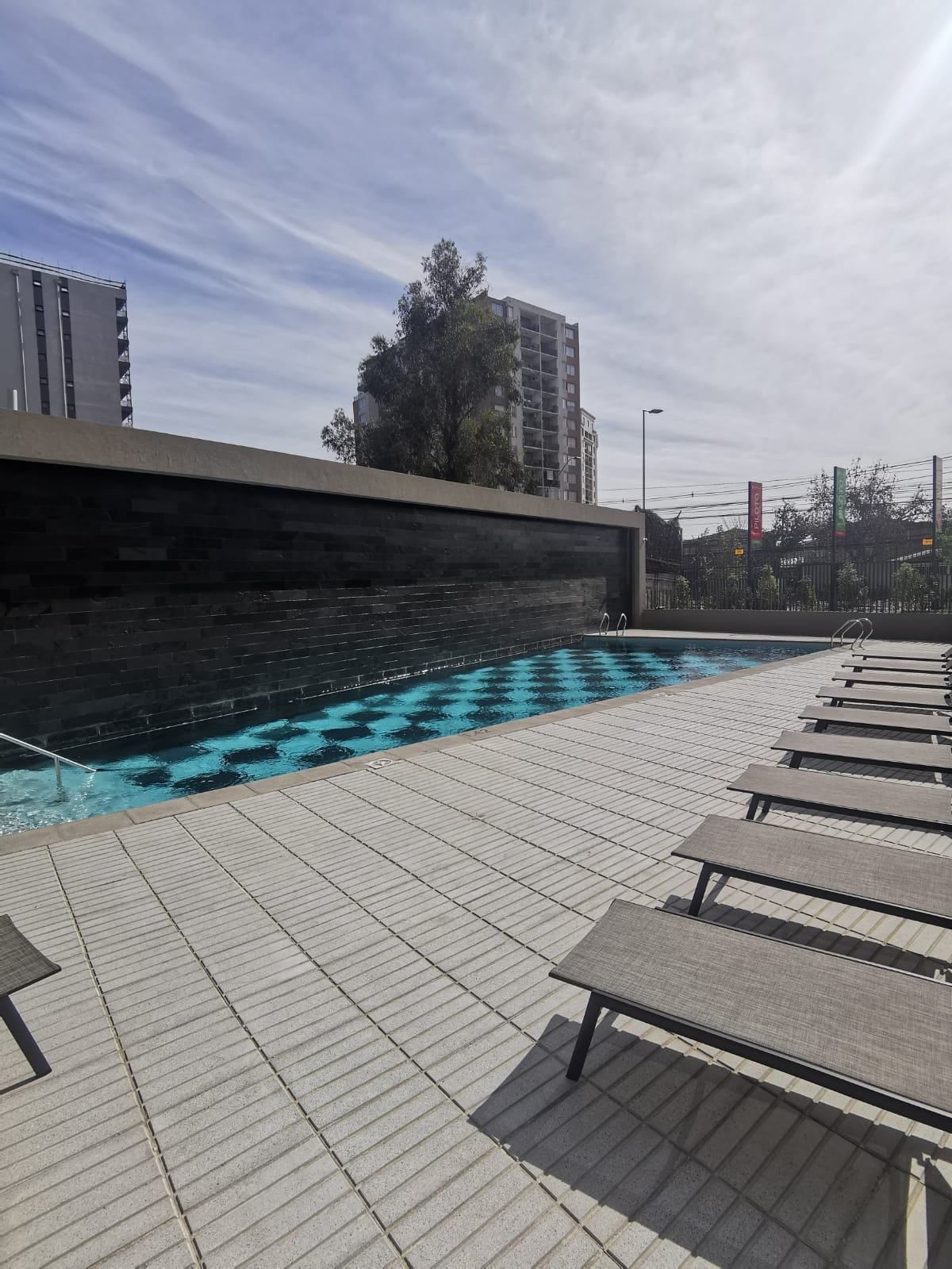Piscina con reposeras de Activa Walker Martínez