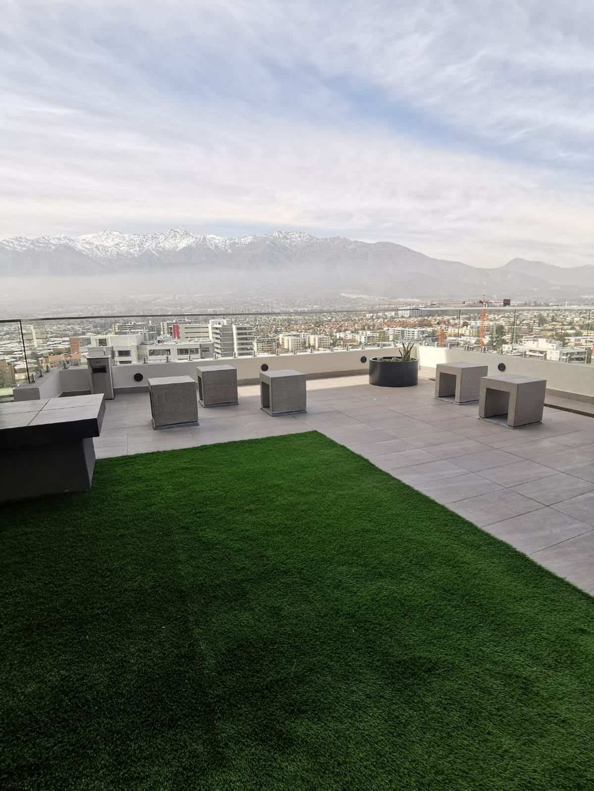 Terraza con pasto en la azotea de Activa Walker Martínez, con vista a la cordillera