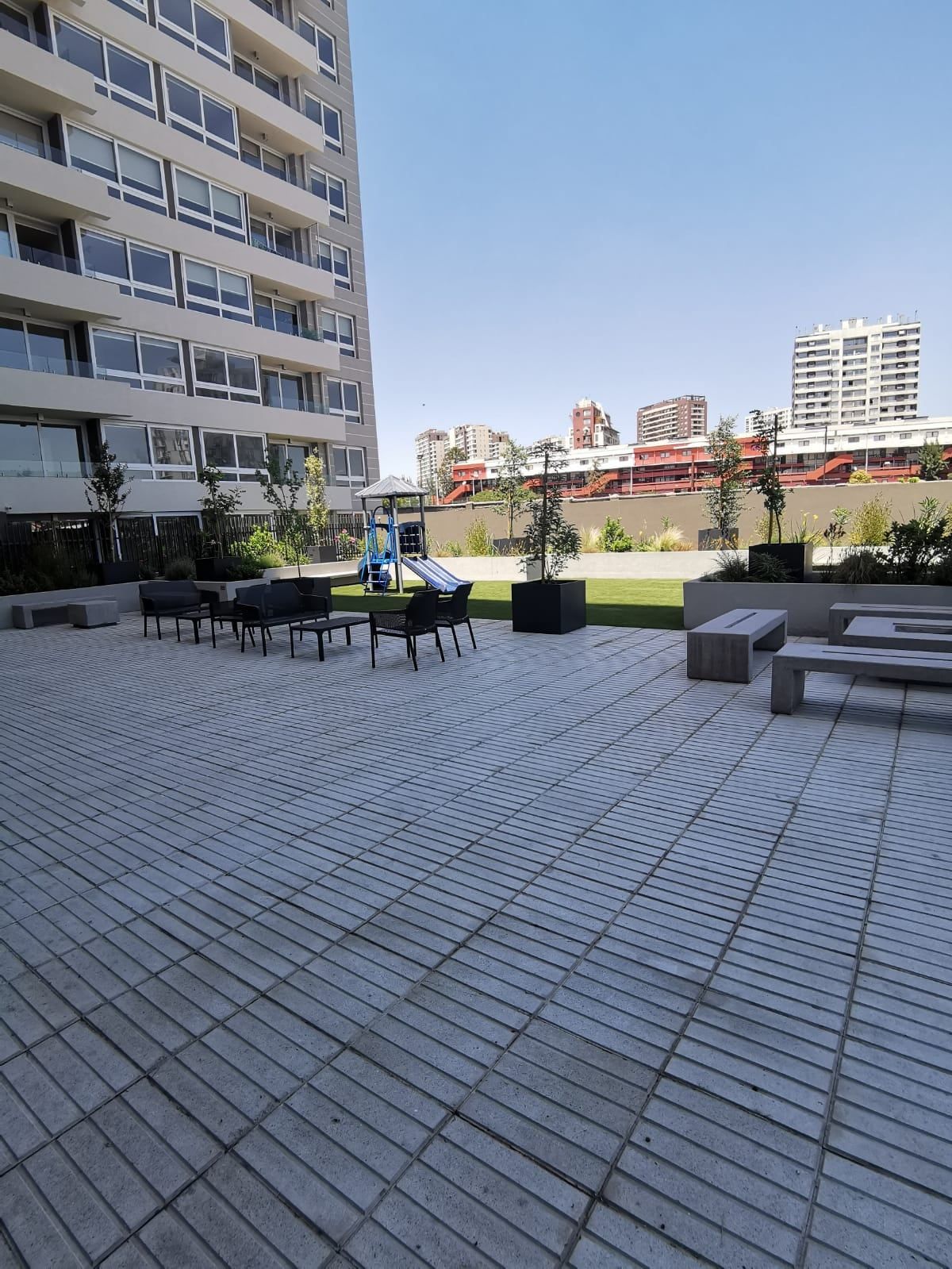 Terraza con mesas junto a la torre de Activa Plaza Chacabuco